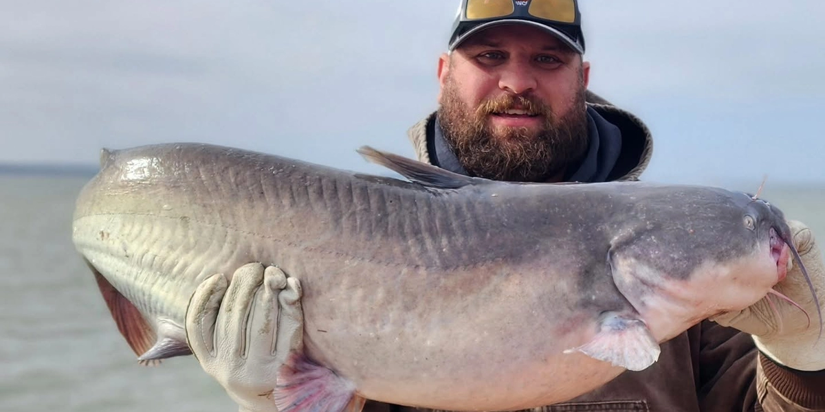 Angler holding a trophy blue catfish at Lake Tawakoni during a guided fishing trip.